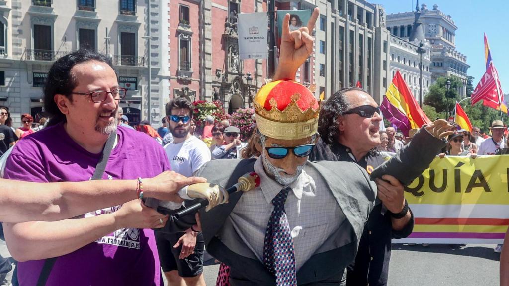 Varias personas llevan una figura del Rey, durante la marcha contra la Monarquía de este domingo.