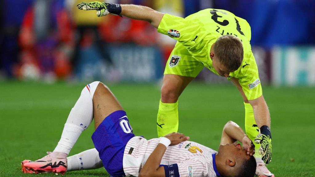 Mbappé, tendido sobre el terreno de juego después de fracturarse la nariz frente a Austria