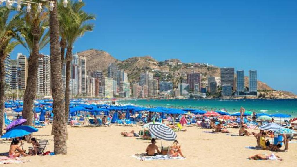 Vista general de una playa de Benidorm repleta de gente.