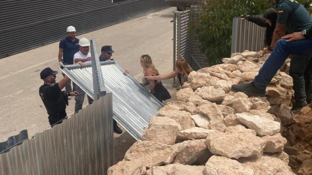 Kimberly y Rachel Wesenauer (ambas en el centro de la imagen) intentan impedir que los trabajadores derrumben un muro de piedra seca en la Finca Langostina.