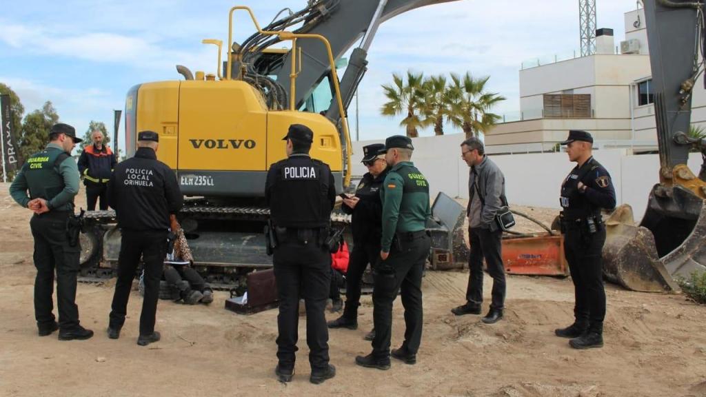 Gabriele Wesenauer y su hija Kimberly se encadenan a la máquina retroexcavadora para detener las obras en Finca Langostina, ante la presencia de la Policía Local y la Guardia Civil.
