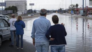 Varias personas observan un tramo de autovía durante una inundación en Valencia en 2022. Jorge Gil EP