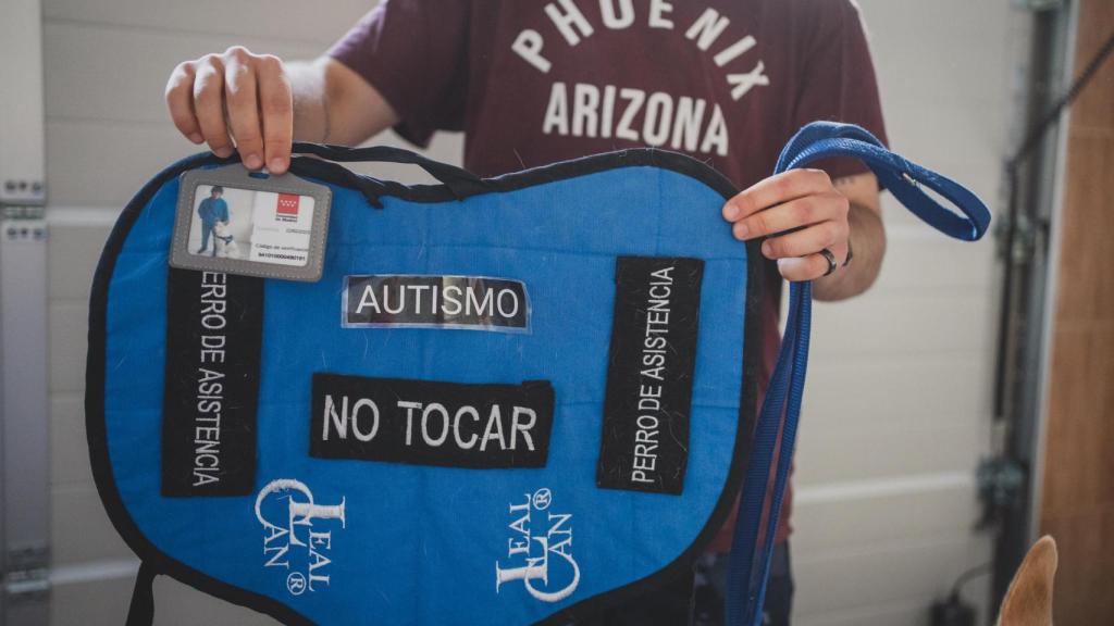 Álex Nogales sujeta el chaleco de Maylo donde se pueden ver las indicaciones de que es un perro de asistencia y no se le puede tocar.