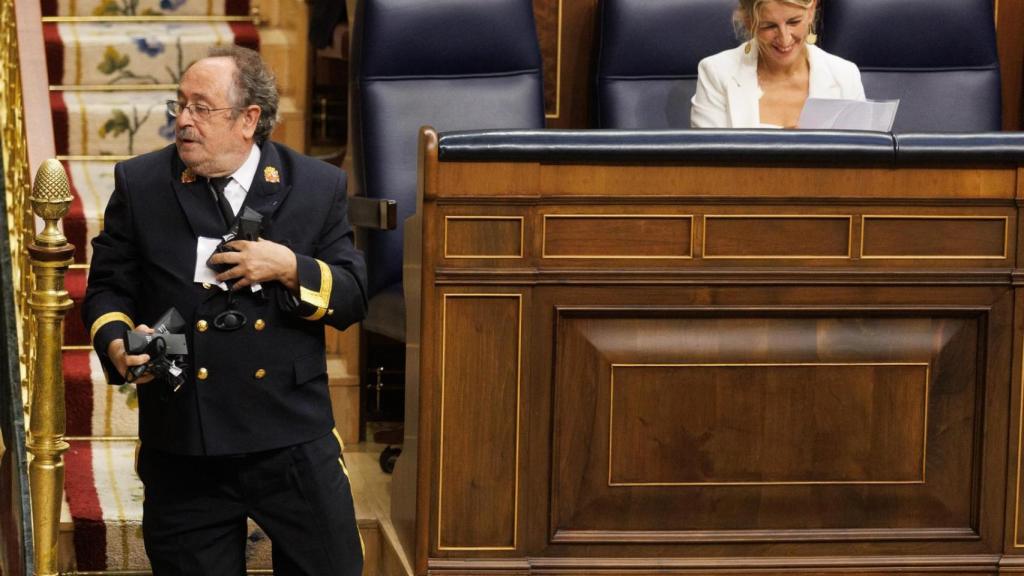 Un bedel del Congreso recoge los receptores abandonados en los escaños en septiembre de 2023.