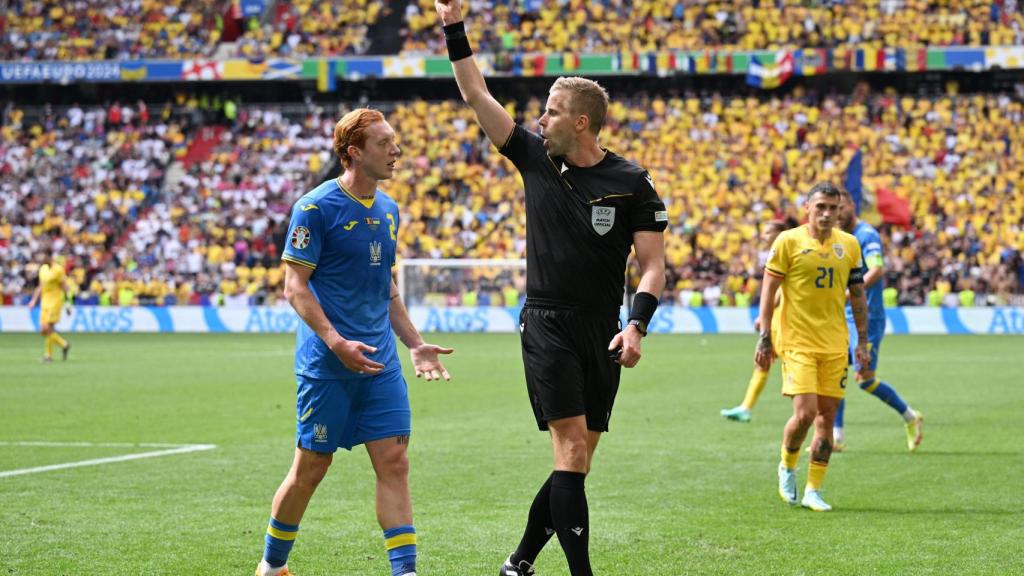 Glenn Nyberg enseña una amarilla a un jugador de Ucrania en la Eurocopa 2024