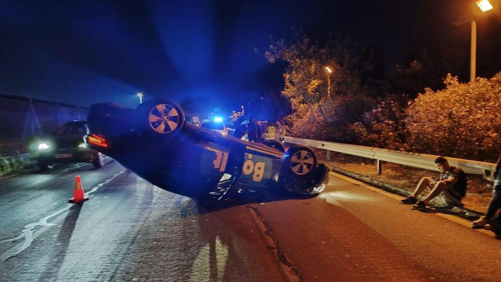 Imagen del VTC accidentado volcado en la carretera.