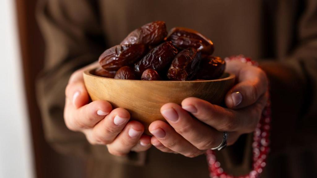 Mujer sosteniendo un bowl con dátiles.