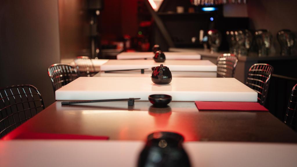 La mesa de ocho comensales con la barra de sushi al fondo.