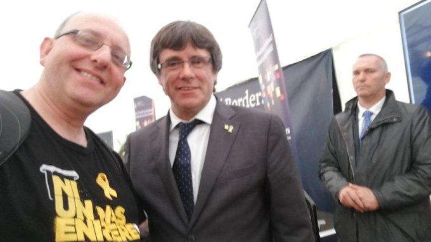Un simpatizante se hace una foto con Puigdemont con Scolà de fondo.
