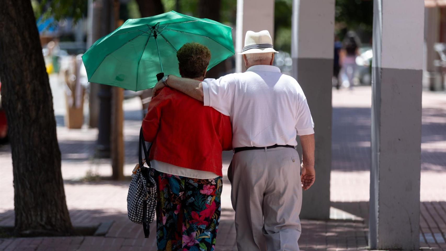 Una pareja de jubilados paseando por la calle.