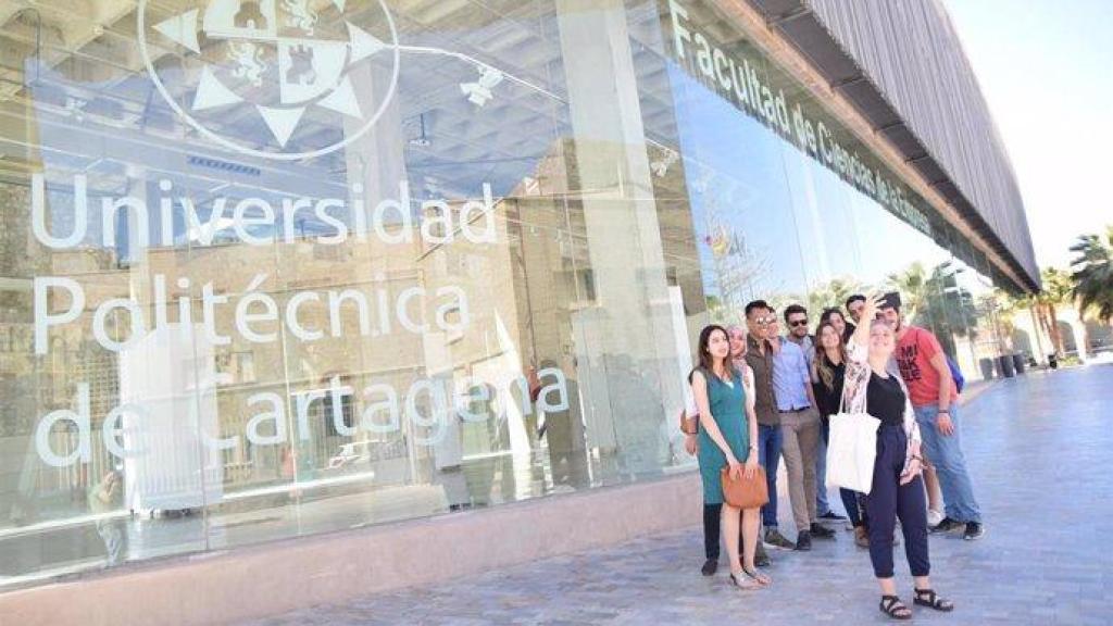 Una foto de archivo de varios alumnos fotografiándose frente a una facultad de la UPCT.