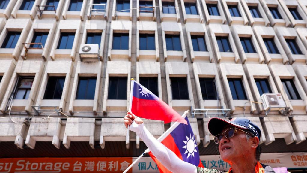 Un seguidor del partido Kuomintang ondea una bandera de Taiwán en las afueras del Parlamento.