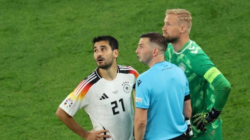 Gündogan, Michael Oliver y Schmeichel miran al techo del Signal Iduna Park.