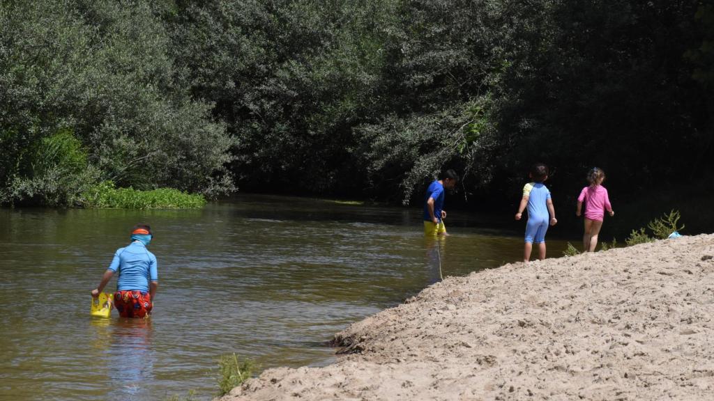 Pequeños en busca de cangrejos en la playa fluvial de Rábano
