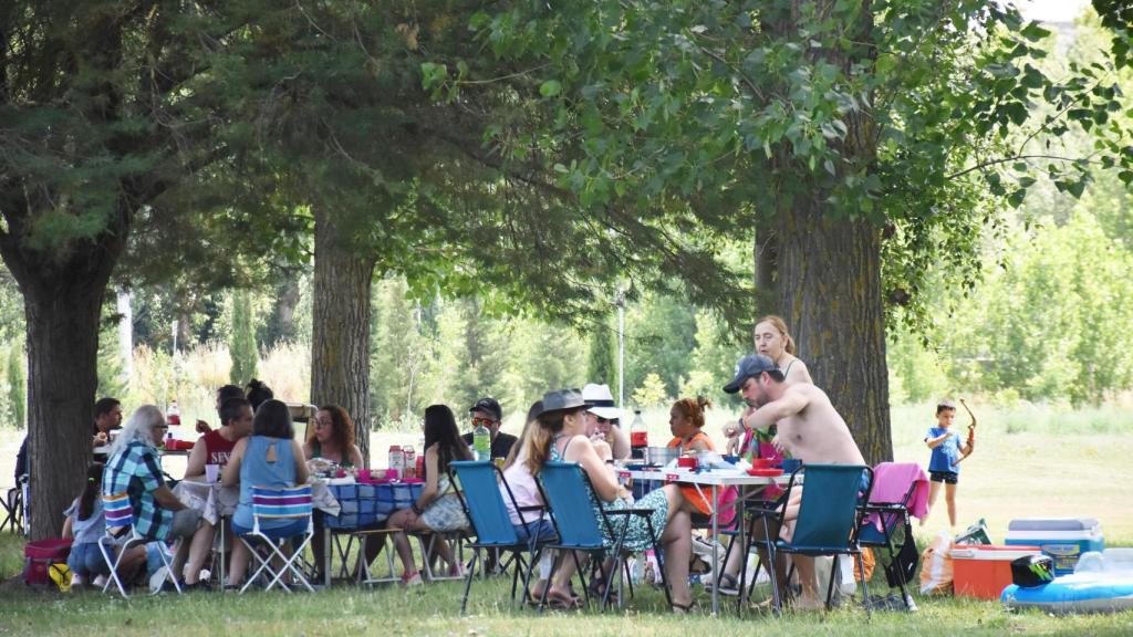 Gente comiendo cerca del agua en la playa fluvial de Rábano