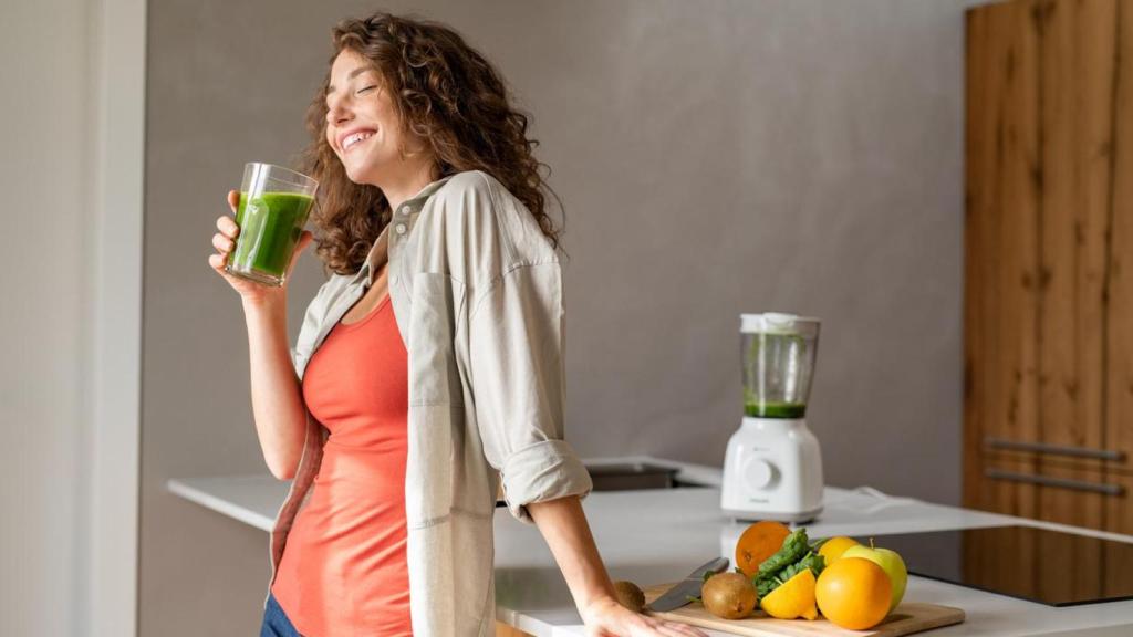 Mujer bebiendo smoothie vegetal.