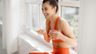 Mujer deportista tomando un suplemento alimenticio.