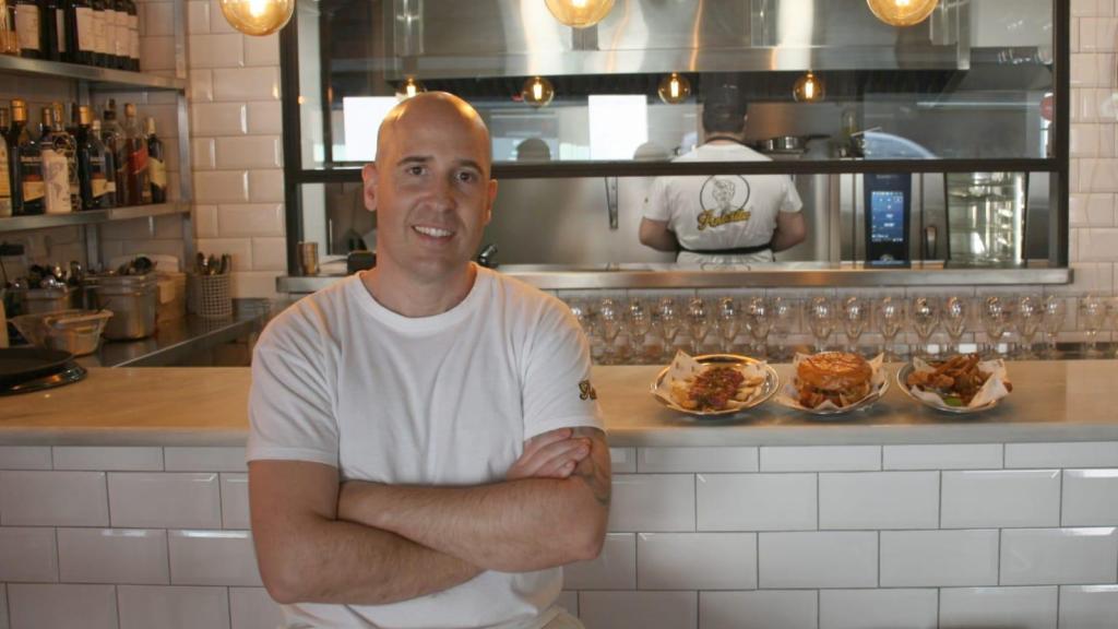 El cocinero Fernando Muyo en la barra de su restaurante Antoñita junto a tres de sus platos, totopos con entraña, hamburguesa de torrezno y oreja crujiente.