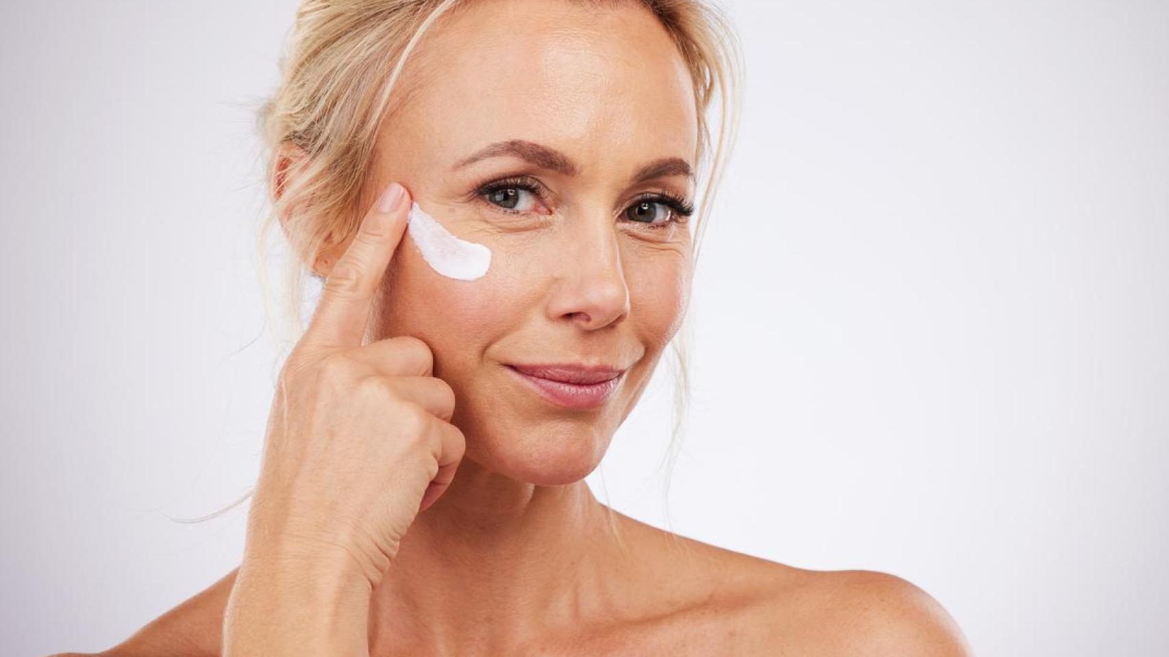 Mujer poniéndose crema en el rostro.