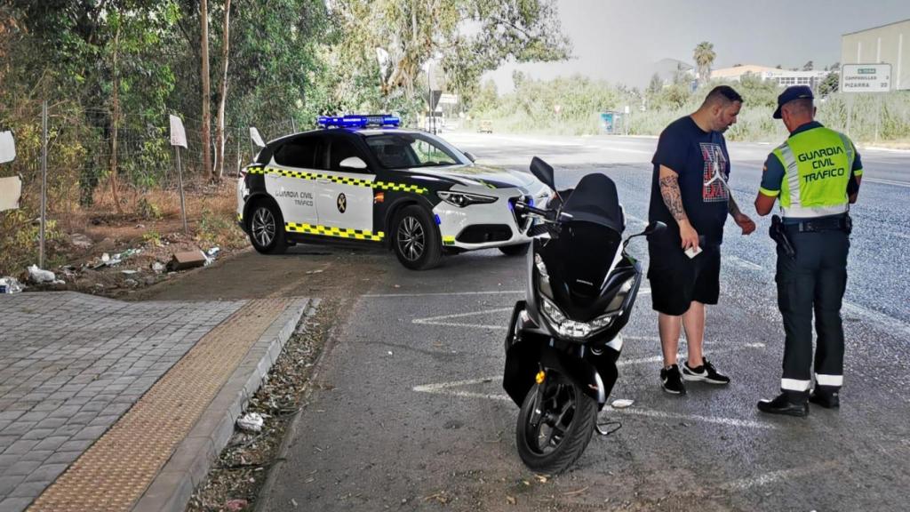 Un guardia civil atiende a un motorista en Málaga.