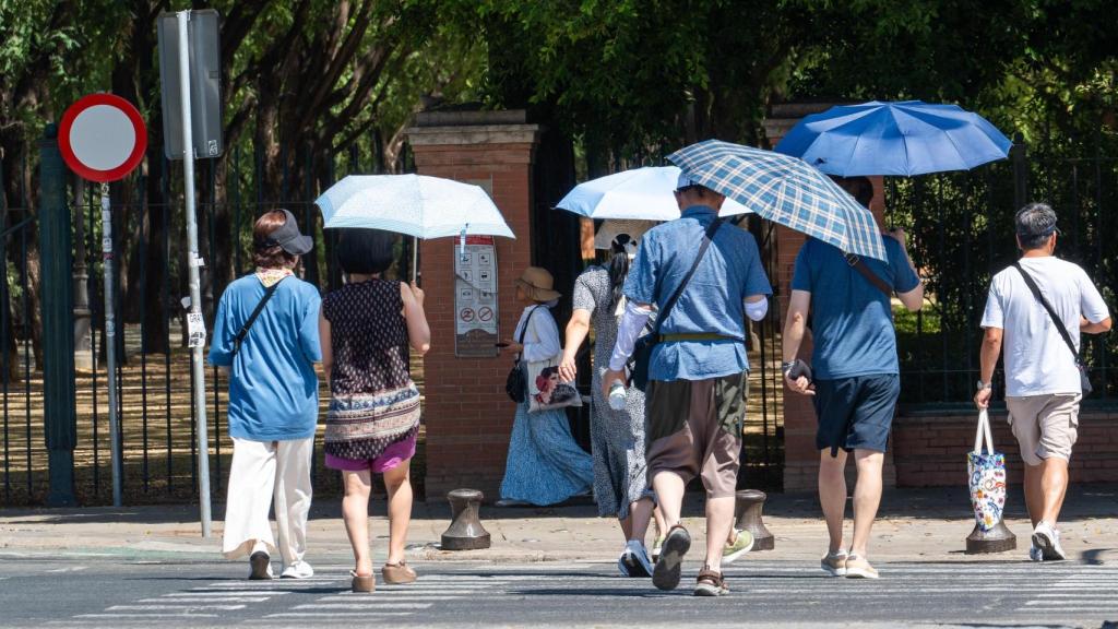 Varias personas se protegen del calor ante las altas temperaturas sevillanas