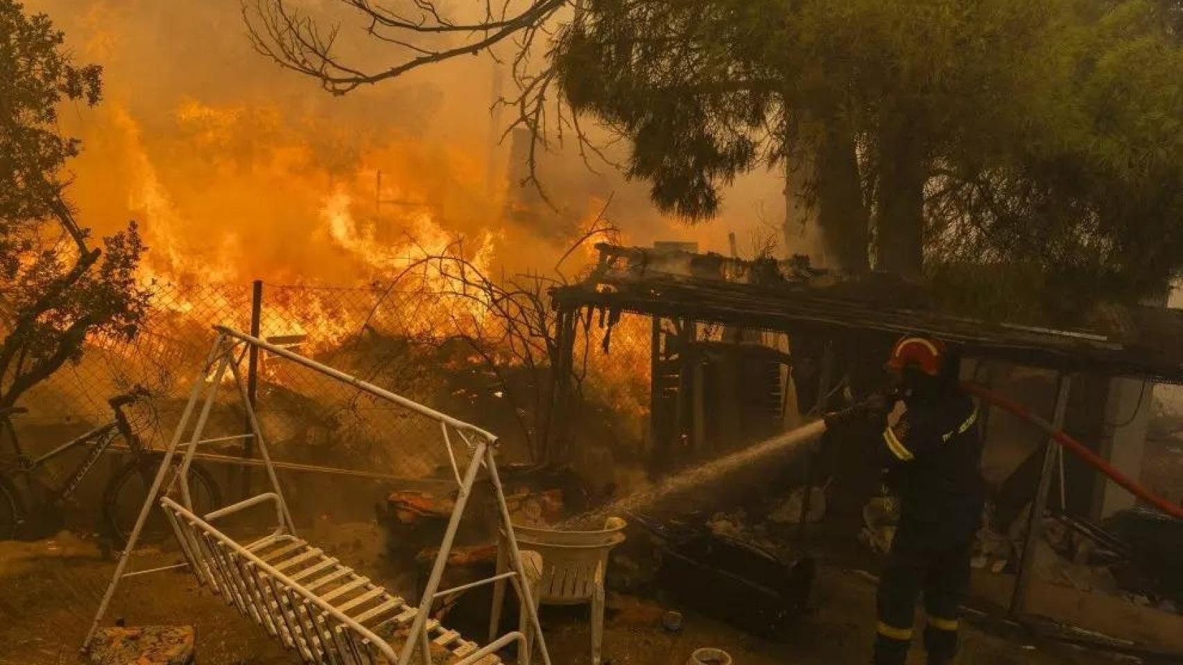 Un bombero combate el fuego en una vivienda al norte de Atenas.
