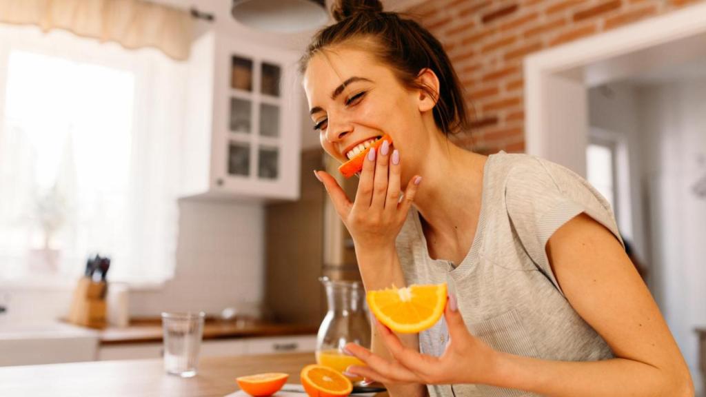 Mujer comiendo fruta.