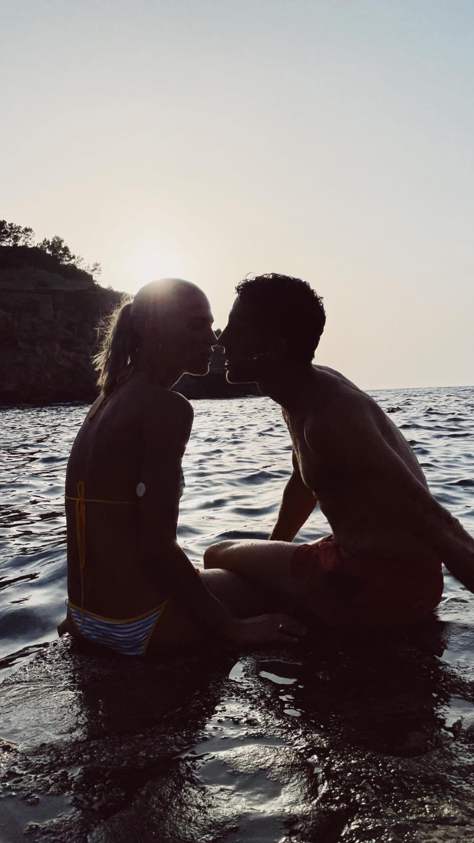 Laura y Manuel, en una romántica instantánea tomada en la playa, besándose.