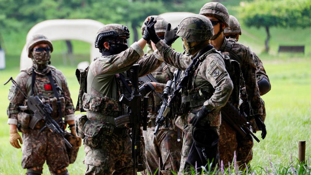 Soldados surcoreanos chocan los cinco tras un simulacro antiterrorista como parte del ejercicio anual de defensa civil Ulchi en el Complejo Deportivo Jamsil de Seou.