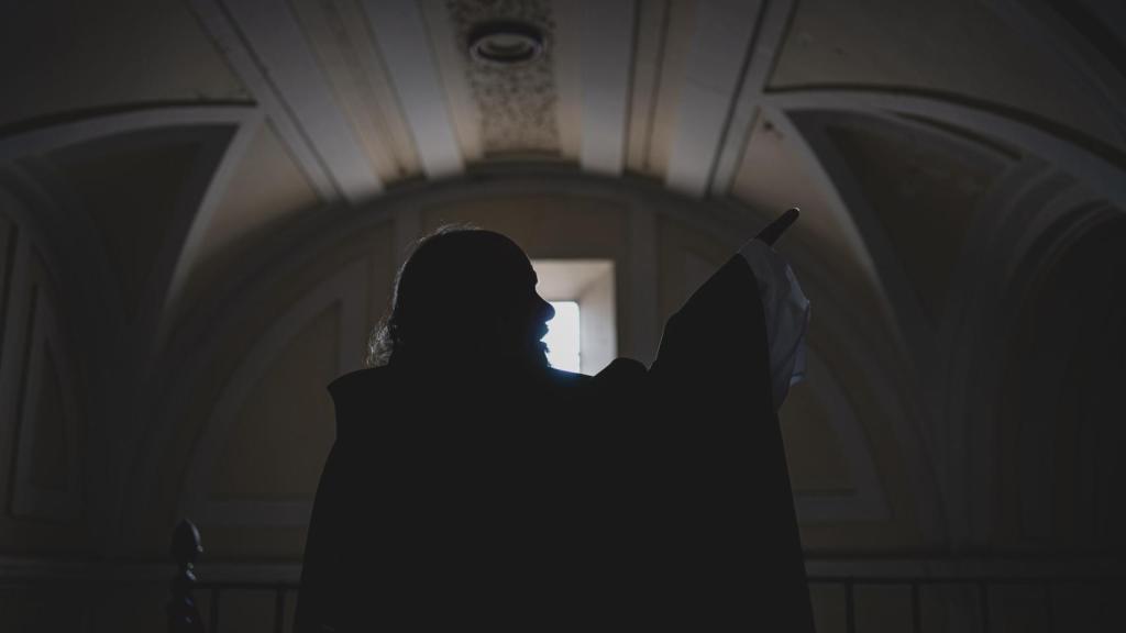 El padre Juan señala hacia el retablo de la iglesia durante la entrevista con EL ESPAÑOL.