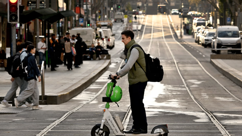 Un hombre circula con un patinete eléctrico por el centro de Melbourne, donde ahora está prohibido.