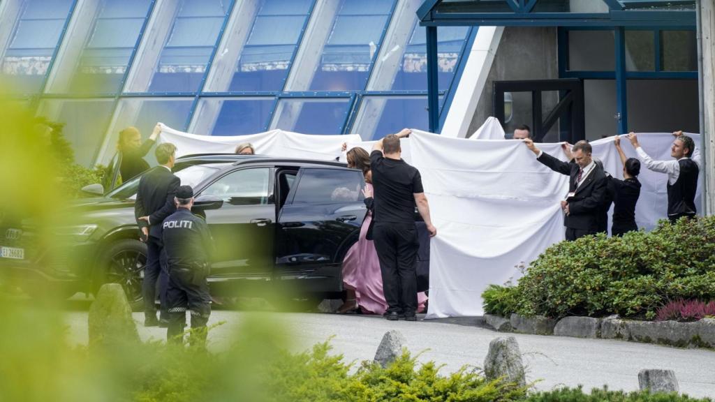 Los novios tapados por una sábana blanca a su salida del hotel Union.