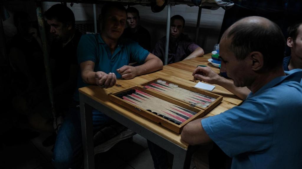 Prisioneros de guerra rusos, capturados por el Ejército ucraniano en Kursk, juegan al backgammon en su celda.