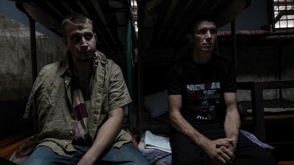 Prisioneros de guerra rusos, capturados por Ucrania durante la ofensiva de Kursk, sentados en sus camas del centro de detención.