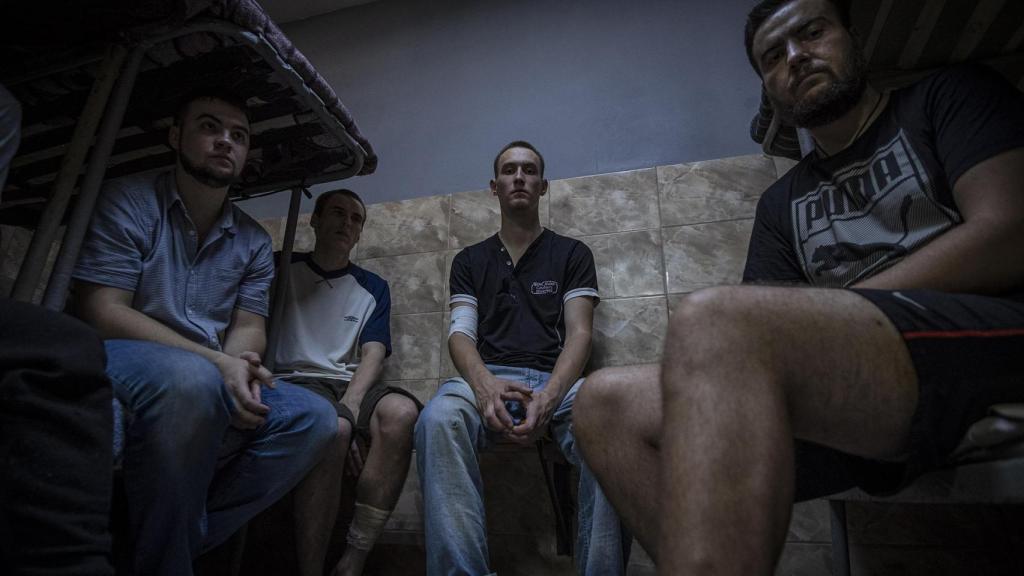 Prisioneros de guerra rusos, captirados por el Ejército ucraniano durante la ofensiva en Kursk, esperan en un centro de detención en Ucrania a ser intercambiados.