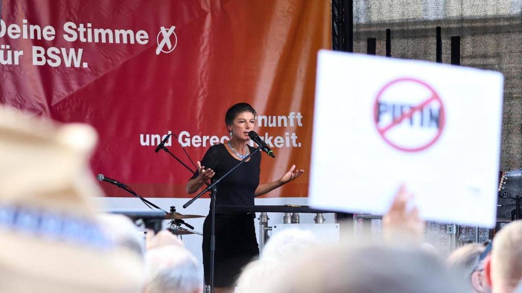Una persona sostiene un cartel anti-Putin, mientras Sahra Wagenknecht habla durante un mitin de campaña electoral para las elecciones del estado de Turingia en Eisenach, Alemania, el 19 de agosto de 2024.