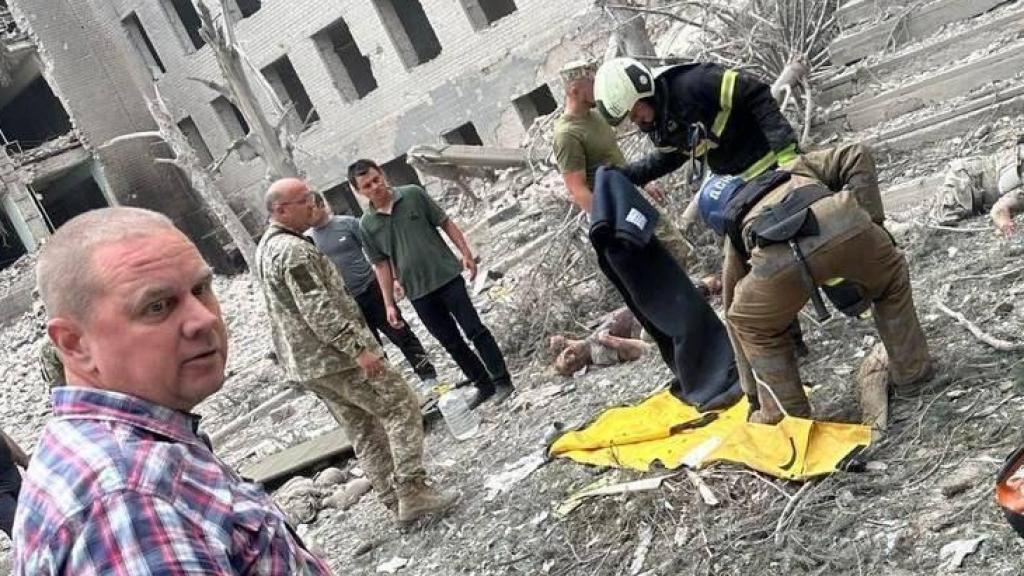 Varias personas y bomberos en Poltava tras el ataque ruso.