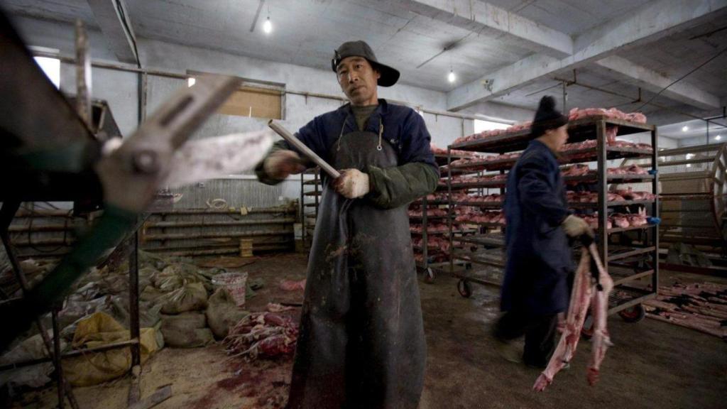 Trabajadores afilan cuchillos antes de quitar la piel a los visones en una granja situada en la ciudad china de Changchun. Imagen de archivo.