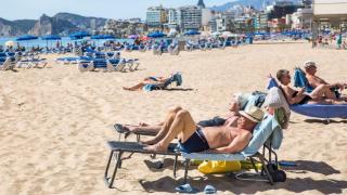 Bañistas tomando el sol en la playa de Poniente, en Benidorm.