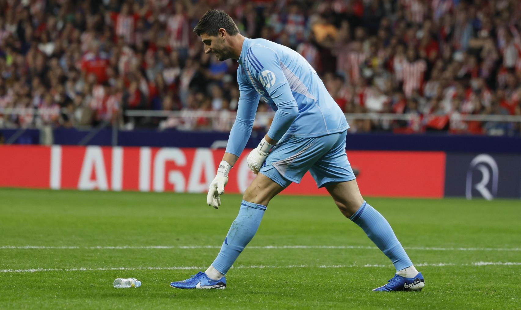 Courtois recoge una botella que le lanzaron desde el Fondo Sur del Metropolitano.