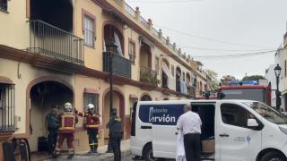 Bomberos, Guardia Civil y servicios funerarios trabajan a las puertas de la vivienda incendiada en Guillena