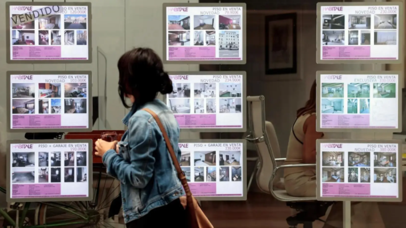 Una persona pasa frente al escaparate de una agencia inmobiliaria.