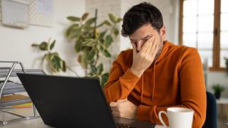 Una persona junto a un ordenador.