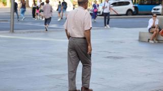 Un señor mayor camina por una calle de Madrid.