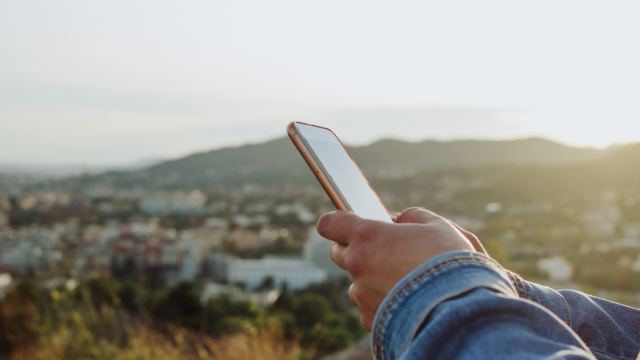 Una persona usando un teléfono móvil en un pueblo