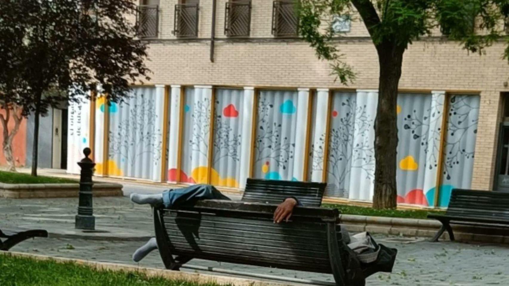 Un hombre durmiendo en un banco de la zona.