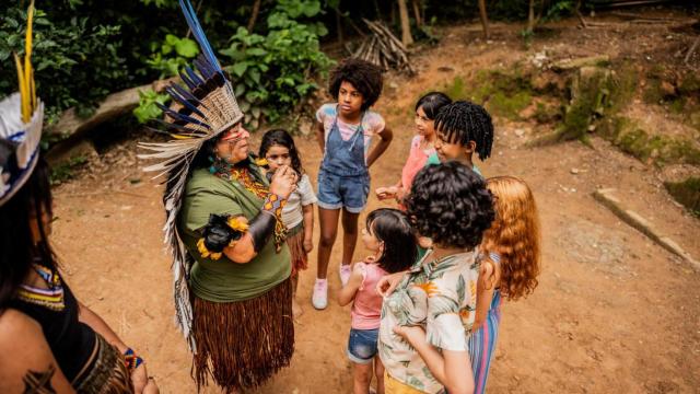 Una mujer indígena habla con niños de una escuela durante una excursión en Brasil.
