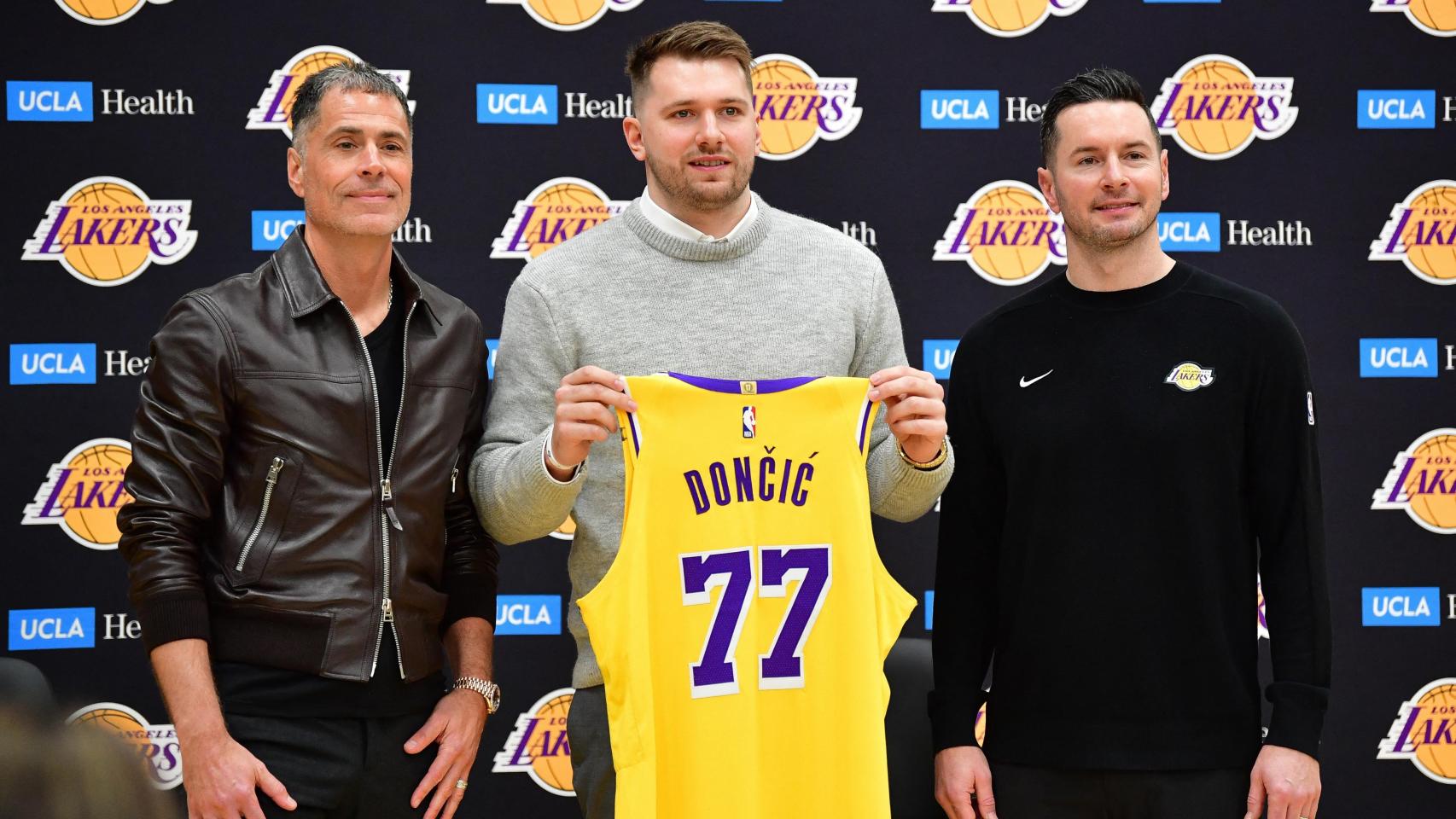 Luka Doncic posa junto a Rob Pelinka (I) y JJ Redick (D) con el dorsal que portará en Los Angeles Lakers
