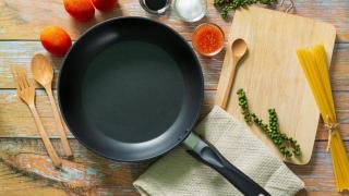 Sartén antiadherente junto a algunos alimentos y utensilios de cocina.