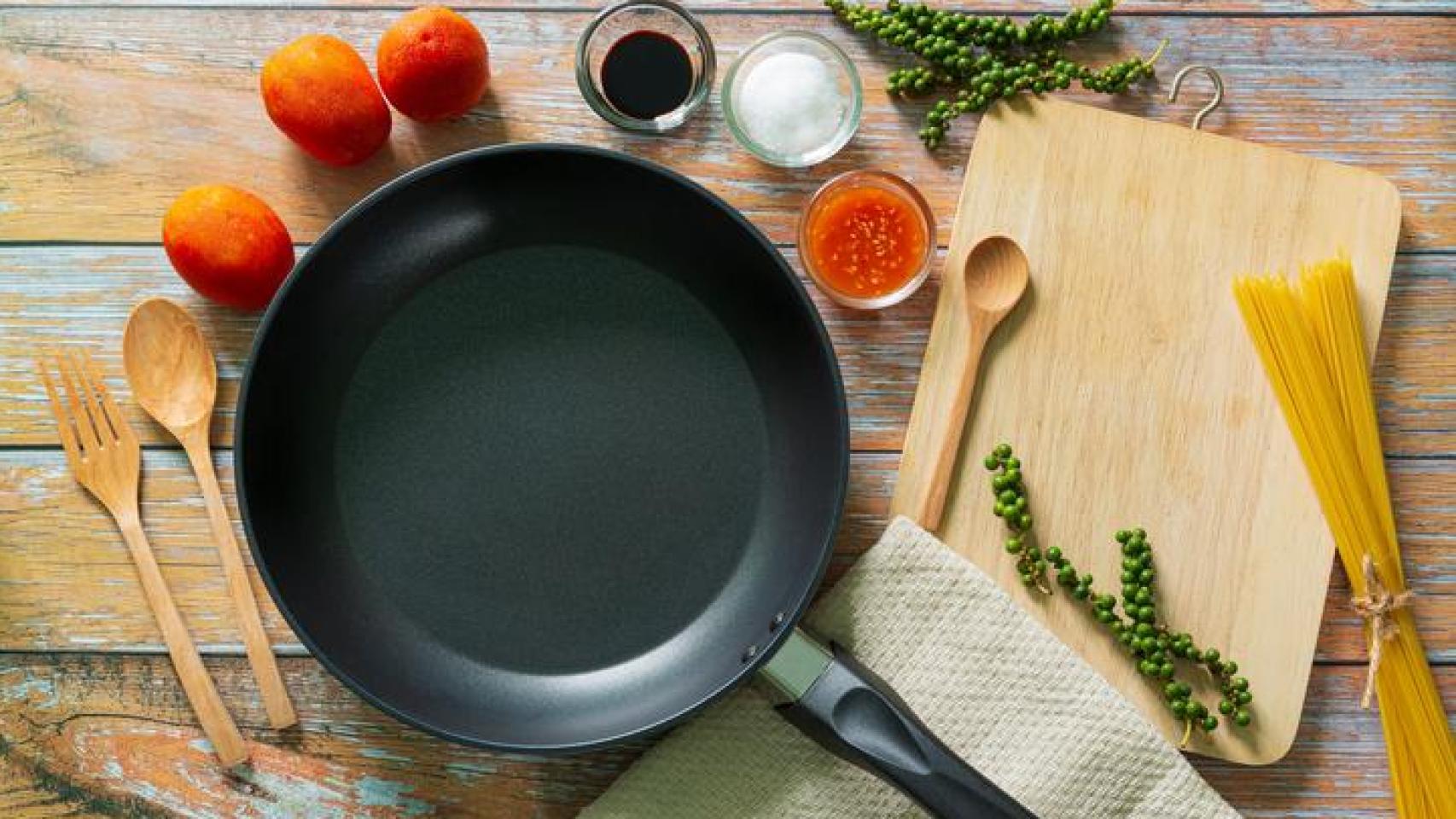 Sartén antiadherente junto a algunos alimentos y utensilios de cocina.